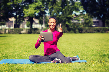 Image showing smiling woman with tablet pc showing thumbs up