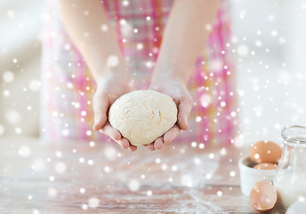 Image showing close up of female hands holding bread dough