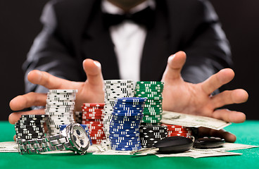 Image showing poker player with chips and money at casino table