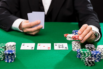 Image showing poker player with cards and chips at casino