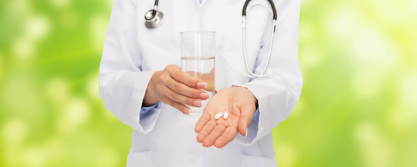 Image showing close up of doctor offering pills and water