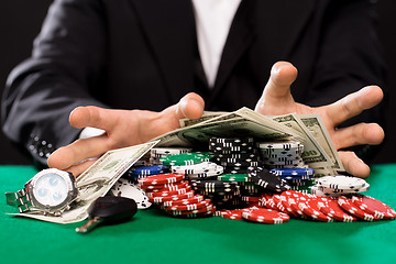 Image showing poker player with chips and money at casino table