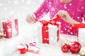 Image showing close up of woman decorating christmas presents