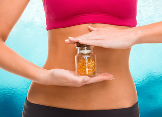 Image showing close up of female hands with bottle of capsules