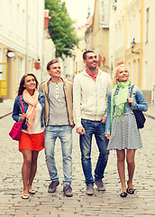 Image showing group of smiling friends walking in the city