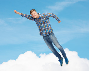 Image showing smiling young man jumping in air