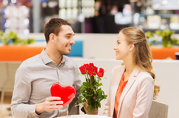 Image showing happy couple with present and flowers in mall