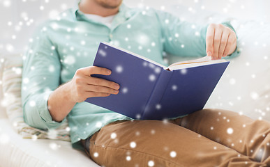 Image showing close up of man reading book at home