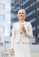 Image showing smiling businesswoman with paper cup outdoors