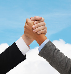 Image showing close up of hands armwrestling over concrete wall