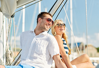 Image showing smiling couple sitting on yacht deck