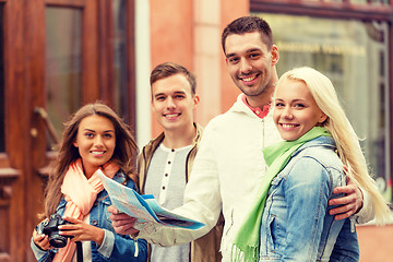 Image showing group of smiling friends with map and photocamera