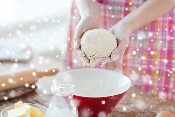 Image showing close up of female hands kneading dough at home