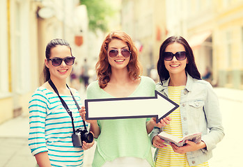 Image showing smiling teenage girls with white arrow outdoors