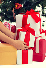 Image showing close up of woman with presents and christmas tree