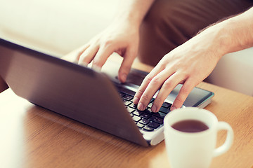 Image showing close up of man with laptop and cup at home