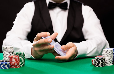 Image showing holdem dealer with playing cards and casino chips