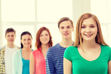 Image showing smiling students with teenage girl in front