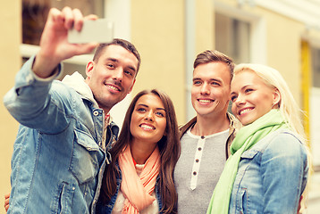 Image showing group of smiling friends making selfie outdoors