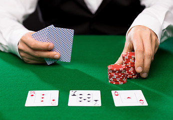 Image showing holdem dealer with playing cards and casino chips