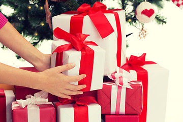 Image showing close up of woman with presents and christmas tree