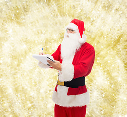 Image showing man in costume of santa claus with notepad