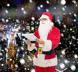 Image showing man in costume of santa claus with notepad