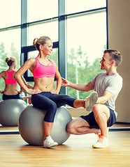 Image showing smiling man and woman with exercise ball in gym