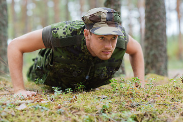 Image showing young soldier or ranger doing push-ups in forest