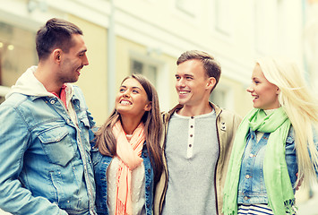 Image showing group of smiling friends walking in the city