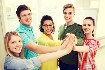 Image showing five smiling students giving high five at school