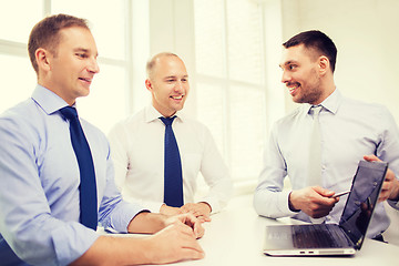 Image showing smiling businessmen having discussion in office