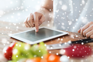 Image showing close up of man reading recipe from tablet pc