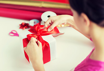 Image showing close up of woman decorating christmas presents