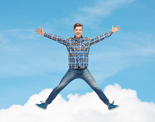 Image showing smiling young man jumping in air