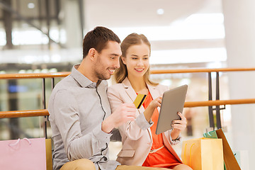 Image showing couple with tablet pc and shopping bags in mall