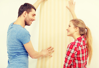 Image showing smiling couple choosing wallpaper for new home