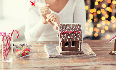 Image showing close up of woman making gingerbread house at home