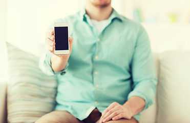 Image showing close up of man sitting with smartphone at home
