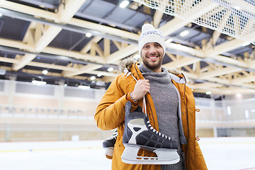 Image showing happy young man with ice-skates on skating rink