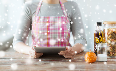 Image showing close up of woman reading recipe from tablet pc