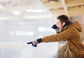 Image showing young man supporting hockey game on skating rink