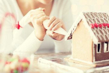 Image showing close up of woman making gingerbread house at home