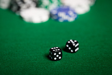 Image showing close up of black dices on green casino table