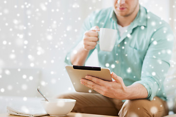 Image showing close up of man with tablet pc having breakfast