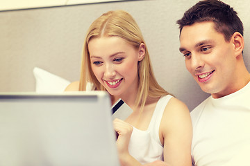 Image showing couple in bed with laptop computer and credit card