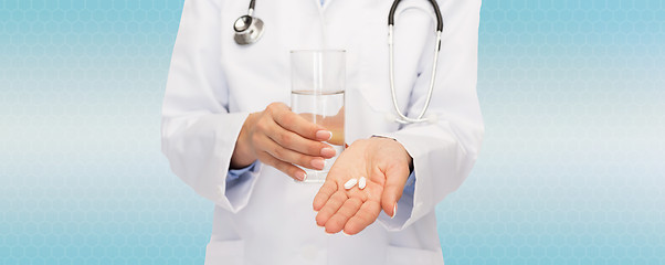 Image showing close up of doctor offering pills and water