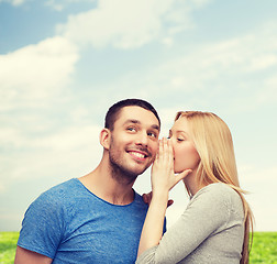 Image showing smiling girlfriend telling boyfriend secret