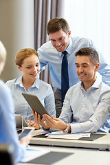 Image showing smiling business people with tablet pc in office