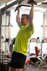 Image showing smiling man exercising in gym